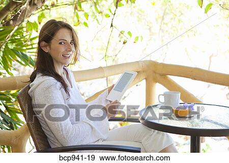 woman reading e-book on balcony View Large Photo Image Stock Photo - woman reading e-book on balcony. Fotosearch