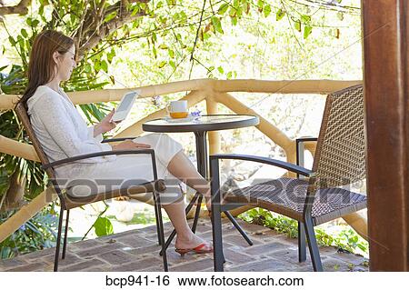 woman reading e-book on balcony View Large Photo Image Stock Photograph - woman reading e-book on balcony. Fotosearch