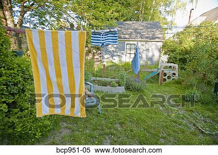 Stock Photography - boy on garden chair under beach towel. Fotosearch
