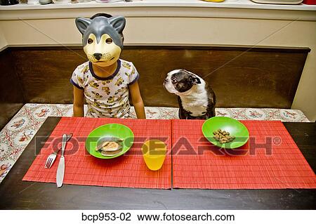 Stock Image - boy wearing dog mask at table. Fotosearch
