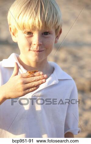 Stock Image - boy with scorpion on hand. Fotosearch