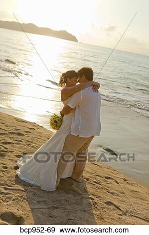 Stock Photo - bridal couple hugging on beach. Fotosearch