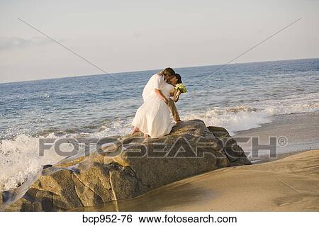 Stock Photograph - bridal couple hugging on beach. Fotosearch