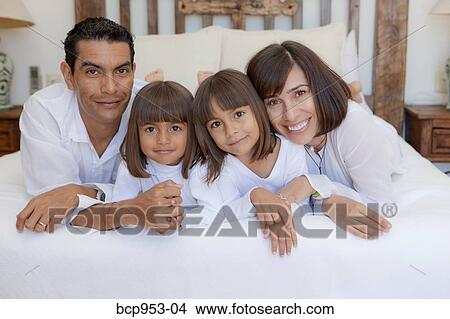 couple with two daughters on bed View Large Photo Image Picture - couple with two daughters on bed. Fotosearch