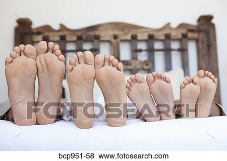 family lying on bed, feet lined up View Large Photo Image Stock Photo - family lying on bed, feet lined up. Fotosearch