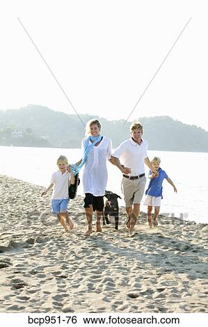 family walking on beach with dogs View Large Photo Image Stock Photograph - family walking on beach with dogs. Fotosearch