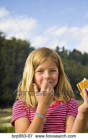 girl eating s'more outdoors View Large Photo Image Stock Photo - girl eating s'more outdoors. Fotosearch