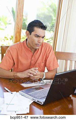 man at table with bills and laptop View Large Photo Image Stock Photo - man at table with bills and laptop. Fotosearch