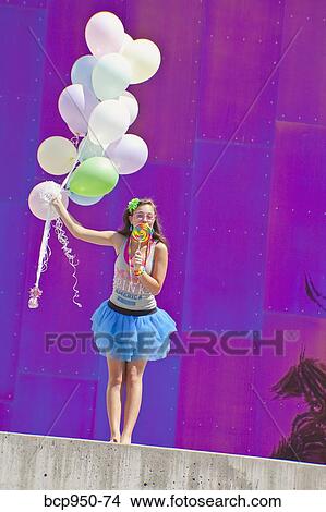 Picture - teen girl holding bunch of balloons. Fotosearch