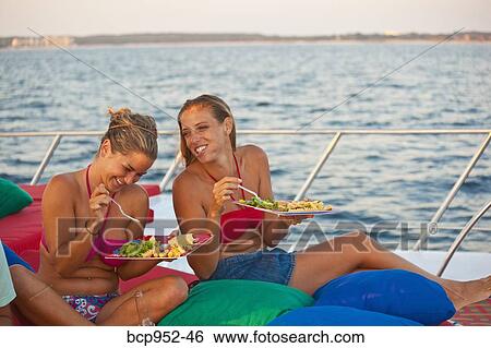 two women eating on deck of yacht View Large Photo Image Stock Photograph - two women eating on deck of yacht. Fotosearch