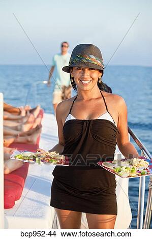 woman on yacht holding plates of food View Large Photo Image Picture - woman on yacht holding plates of food. Fotosearch