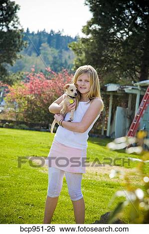 young girl holding puppy outdoors View Large Photo Image Stock Photograph - young girl holding puppy outdoors. Fotosearch