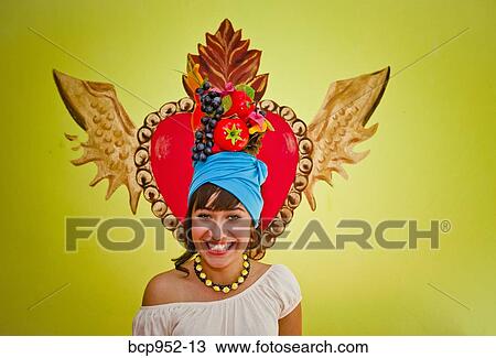 Stock Image - young woman wearing fruit hat. Fotosearch