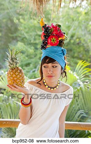 Stock Photo - young woman wearing fruit hat. Fotosearch