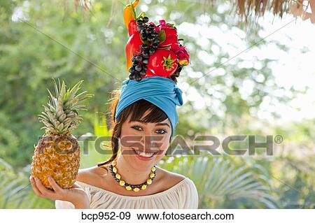Stock Photo - young woman wearing fruit hat. Fotosearch