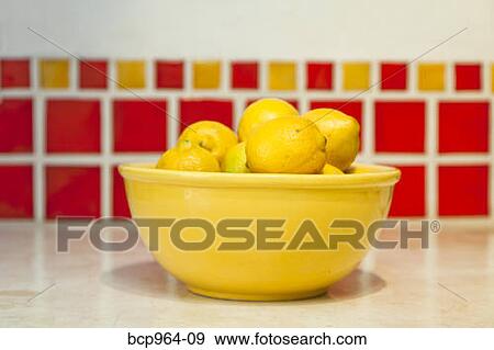 Bowl of lemons on counter with red tiles behind View Large Photo Image Stock Photo - Bowl of lemons on counter with red tiles behind. Fotosearch