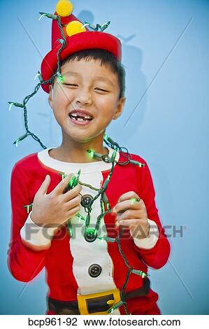 Boy in red costume with holiday lights View Large Photo Image Stock Image - Boy in red costume with holiday lights. Fotosearch