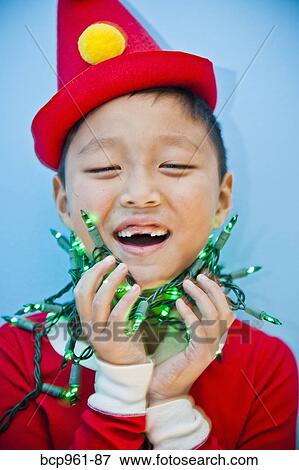 Boy in red costume with holiday lights View Large Photo Image Stock Photo - Boy in red costume with holiday lights. Fotosearch