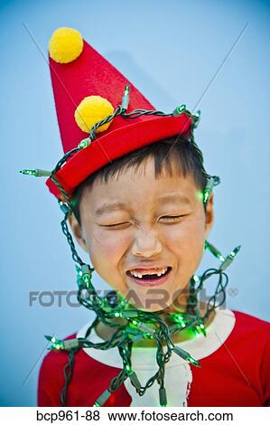 Boy in red costume with holiday lights View Large Photo Image Stock Photo - Boy in red costume with holiday lights. Fotosearch