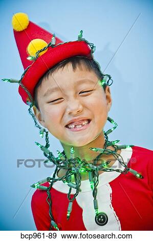Stock Photo - Boy in red costume with holiday lights. Fotosearch