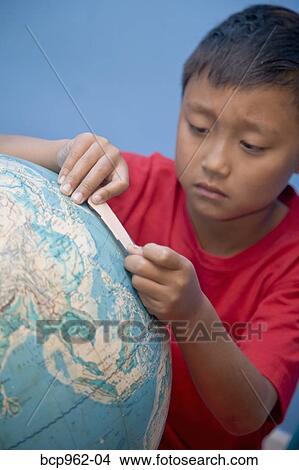Boy placing bandaid on globe View Large Photo Image Picture - Boy placing bandaid on globe. Fotosearch