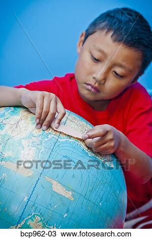 Boy placing bandaid on globe View Large Photo Image Stock Image - Boy placing bandaid on globe. Fotosearch