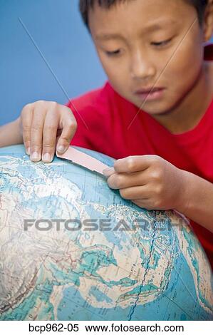 Boy placing bandaid on globe View Large Photo Image Stock Photography - Boy placing bandaid on globe. Fotosearch