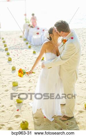 Stock Image - Bridal couple kissing on beach. Fotosearch