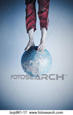 Stock Photo - Feet and legs on globe. Fotosearch