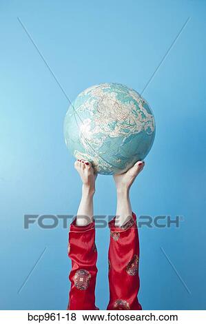 Stock Photo - Feet holding globe. Fotosearch