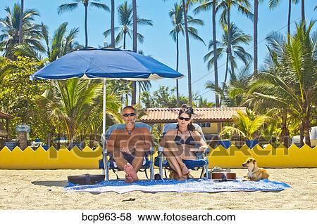 Grumpy man and woman on beach chairs under umbrella View Large Photo Image Stock Photo - Grumpy man and woman on beach chairs under umbrella. Fotosearch