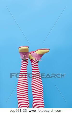 Stock Image - Legs in striped socks with colorful shoes. Fotosearch