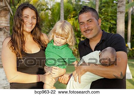 Man and woman holding baby and young child outdoors View Large Photo Image Stock Image - Man and woman holding baby and young child outdoors. Fotosearch
