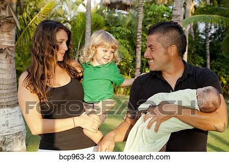 Man and woman holding baby and young child outdoors View Large Photo Image Stock Image - Man and woman holding baby and young child outdoors. Fotosearch
