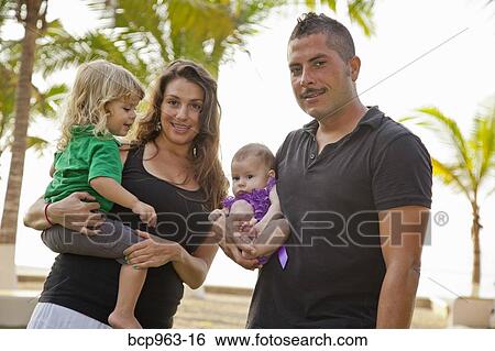 Man and woman holding baby and young child outdoors View Large Photo Image Stock Photograph - Man and woman holding baby and young child outdoors. Fotosearch