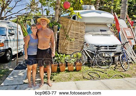 Man and woman standing between campers View Large Photo Image Stock Photo - Man and woman standing between campers. Fotosearch