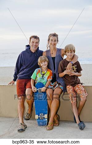 Stock Photography - Man and woman with two boys on beach boardwalk. Fotosearch