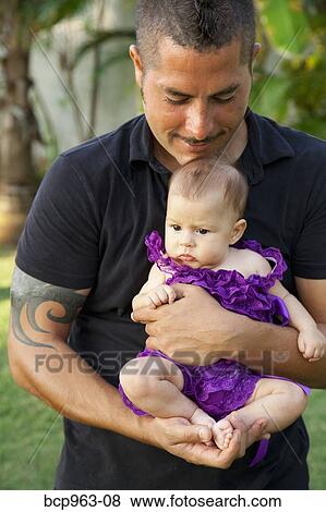 Man in black clothing holding baby girl View Large Photo Image Stock Photo - Man in black clothing holding baby girl. Fotosearch