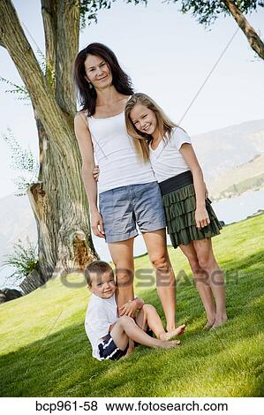 Stock Photo - Outdoor portrait of woman with two young children. Fotosearch