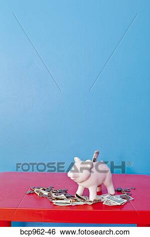 Stock Photograph - Piggy bank on red table. Fotosearch