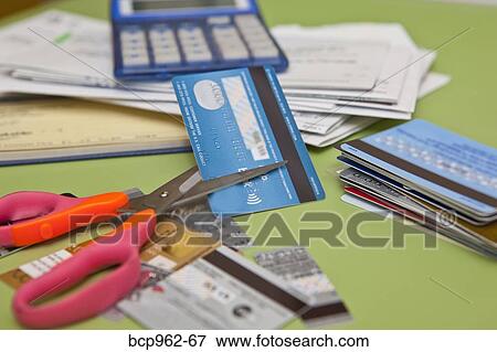 Stock Photo - Scissors cutting up credit cards. Fotosearch