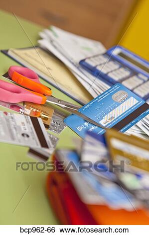 Stock Photograph - Scissors cutting up credit cards. Fotosearch