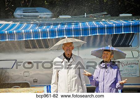 Senior couple in rain hats near airstream camper View Large Photo Image Stock Image - Senior couple in rain hats near airstream camper. Fotosearch
