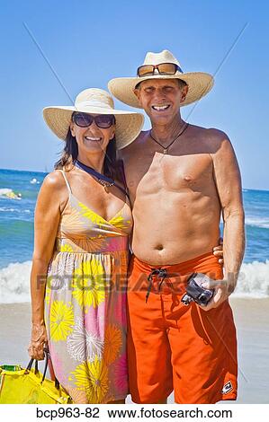 Smiling man and woman arm in arm on beach View Large Photo Image Stock Image - Smiling man and woman arm in arm on beach. Fotosearch