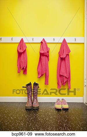 Sweaters on hooks with boots and shoes below View Large Photo Image Stock Photo - Sweaters on hooks with boots and shoes below. Fotosearch