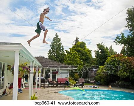 Teen boy jumping off roof into pool View Large Photo Image Stock Image - Teen boy jumping off roof into pool. Fotosearch