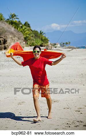 Teen girl running on beach with towel cape View Large Photo Image Stock Image - Teen girl running on beach with towel cape. Fotosearch