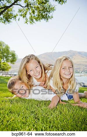 Picture - Three young children playing in lakeside park. Fotosearch