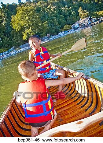 Stock Photograph - Two young boys paddling canoe. Fotosearch