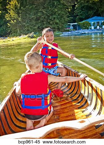 Stock Photography - Two young boys paddling canoe. Fotosearch
